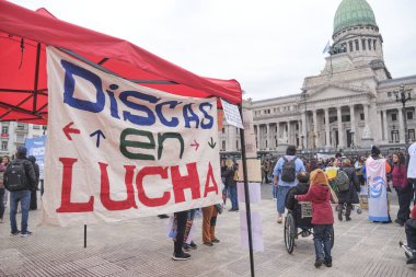 Buenos Aires, Arjantin; 10 Temmuz 2025: Engelli haklarını savunmak ve Engelli Acil Durum Yasasını desteklemek amacıyla Kongre önünde toplanın. Poster: Mücadeledeki diskler.