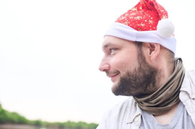 Dışarıda, doğal bir manzarada Noel şapkası takan genç bir İspanyol 'un portresi. Yüzünde çılgın bir gülümsemeyle bir tarafa bakıyor..