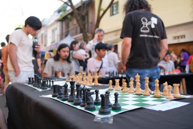 Buenos Aires, Argentina; October 4, 2025: People playing chess during the Flores Book Fair, a free outdoor event with book and craft stalls, book presentations, talks, cultural activities, and games for children.