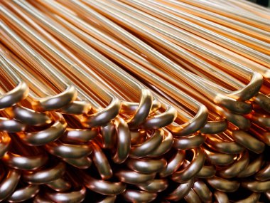 Üretim tesisinde düzgünce istiflenmiş bakır boruların yakın çekim görüntüsü, parlaklık ve pürüzsüz dokularını gözler önüne seriyor, endüstriyel ve tesisat uygulamaları için ideal..