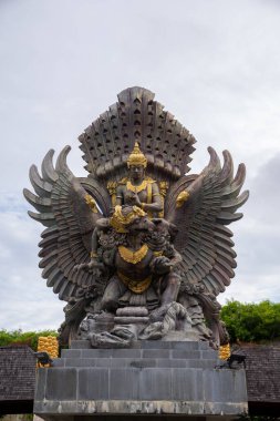 Endonezya tanrısının heykeli, efsanevi kuş ve Endonezya 'nın ulusal amblemi bulutlu bir gökyüzüne karşı dizilmiş.