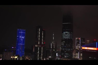 Malezya, Kuala Lumpur, 05.15.2024 - Yağmurlu havada büyüleyici bir gece görüntüsü, yıldırımlar ve aydınlatılmış gökdelenler bir fırtına sırasında şehrin canlı enerjisi.