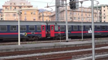 GENOA, ITALY, NOVEMBER 06 2024 - Trenitalia 'nın iki adet E464 lokomotifli Şehirler Arası Gece Treni Cenova Brignole' ye ulaşarak çağdaş ulaşımın verimliliğini ve hızını vurguluyor. Arkaplanda mimari ve altyapı yer alıyor.