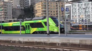 GENOA, ITALY, NOVEMBER 06 2024 - Hitachi ETR 104-075 elektrikli tren yeni Trenitalia Bölgesel Ahırı Cenova Brignole 'den ayrılan, başka bir gelen tren - platform. eko-dost taşımacılığa vurgu yapıyor.