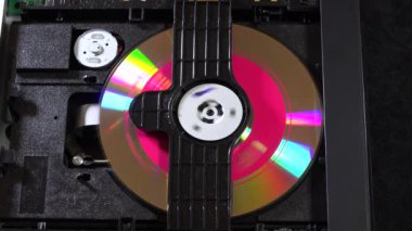 Açık bir DVD oynatıcı, çeşitli açılardan görülen disk yükleme ve boşaltma hareketleri ile dahili bileşenlerini ve devrelerini gösterir. Bu resim ev eğlence sistemlerinin teknolojisini ve tasarımını vurgular.