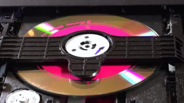 Açık bir DVD oynatıcı, çeşitli açılardan görülen disk yükleme ve boşaltma hareketleri ile dahili bileşenlerini ve devrelerini gösterir. Bu resim ev eğlence sistemlerinin teknolojisini ve tasarımını vurgular.
