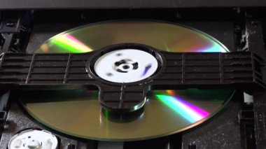 Açık bir DVD oynatıcı, çeşitli açılardan görülen disk yükleme ve boşaltma hareketleri ile dahili bileşenlerini ve devrelerini gösterir. Bu resim ev eğlence sistemlerinin teknolojisini ve tasarımını vurgular.