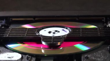 Açık bir DVD oynatıcı, çeşitli açılardan görülen disk yükleme ve boşaltma hareketleri ile dahili bileşenlerini ve devrelerini gösterir. Bu resim ev eğlence sistemlerinin teknolojisini ve tasarımını vurgular.