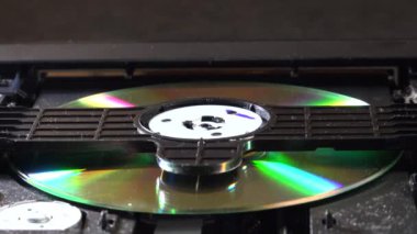 Açık bir DVD oynatıcı, çeşitli açılardan görülen disk yükleme ve boşaltma hareketleri ile dahili bileşenlerini ve devrelerini gösterir. Bu resim ev eğlence sistemlerinin teknolojisini ve tasarımını vurgular.