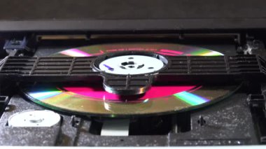 Açık bir DVD oynatıcı, çeşitli açılardan görülen disk yükleme ve boşaltma hareketleri ile dahili bileşenlerini ve devrelerini gösterir. Bu resim ev eğlence sistemlerinin teknolojisini ve tasarımını vurgular.