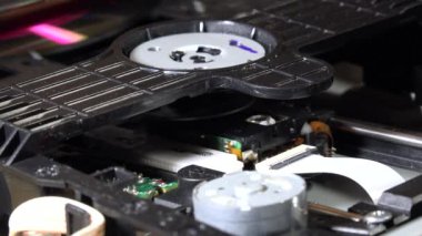 Açık bir DVD oynatıcı, çeşitli açılardan görülen disk yükleme ve boşaltma hareketleri ile dahili bileşenlerini ve devrelerini gösterir. Bu resim ev eğlence sistemlerinin teknolojisini ve tasarımını vurgular.