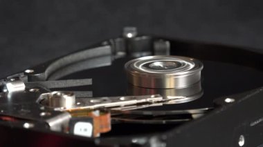 Veri depolama ve işlevsellik için gerekli karmaşık mekanik parçaların vurgulandığı, dönen bir sabit diskin iç bileşenlerini gösteren ayrıntılı bir yakın çekim resmi.