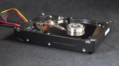 Açık bir sabit disk sürücüsünün detaylı bir görüntüsü, açıkta duran plakalar ve okuma-yazma kolu başlangıç, hareket ve kapatma. Veri depolama, teknoloji veya bilgisayar donanımı ile ilgili kavramlar için ideal.