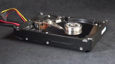 Açık bir sabit disk sürücüsünün detaylı bir görüntüsü, açıkta duran plakalar ve okuma-yazma kolu başlangıç, hareket ve kapatma. Veri depolama, teknoloji veya bilgisayar donanımı ile ilgili kavramlar için ideal.