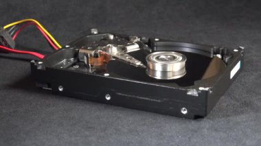 Açık bir sabit disk sürücüsünün detaylı bir görüntüsü, açıkta duran plakalar ve okuma-yazma kolu başlangıç, hareket ve kapatma. Veri depolama, teknoloji veya bilgisayar donanımı ile ilgili kavramlar için ideal.