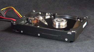 Açık bir sabit disk sürücüsünün detaylı bir görüntüsü, açıkta duran plakalar ve okuma-yazma kolu başlangıç, hareket ve kapatma. Veri depolama, teknoloji veya bilgisayar donanımı ile ilgili kavramlar için ideal.