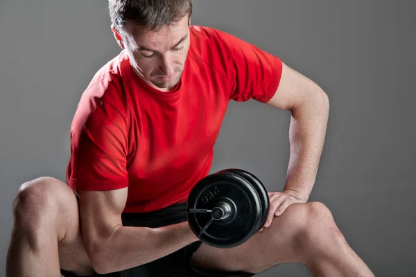 stock image Caucasian man practicing fitness in gym with red t-shirt and other accessories. 