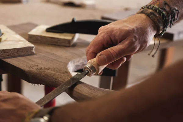 用一个文件仔细地塑造和环绕木材的熟练木匠的手的特写镜头 每一招都能让木料达到完美的形态 见证其艺术性 — 图库照片