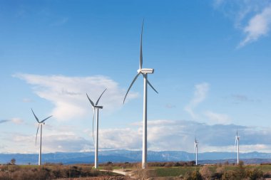 Arka planda Pireneler 'in dağları olan rüzgar tarlası manzarası