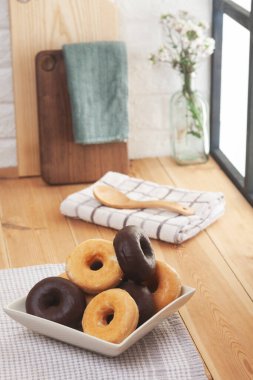 Ön planda çörek tabağı ve arka planda mutfak tezgahları.. 