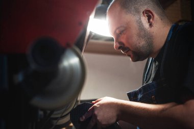 Ayakkabı boyama makinesinde ayakkabı boyacısı.