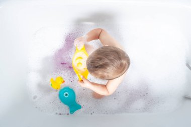 Yukardan aşağıya bakınca, çocukların şakacı soytarılıklarını, baloncuklar ve neşe içinde küvette yakalıyor.. 