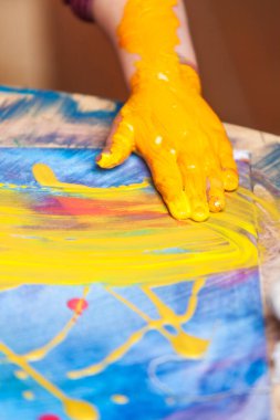 Yaratıcı bir aktivite sırasında tuvalini boyadığı altın boyayla dolu bir çocuğun detaylı görüntüsü.. 
