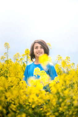 Çocuk baharda çiçek açan bir kolza tohumu tarlasında