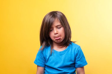 Mavi tişörtlü çocuk hüzün ve kederin harika bir yüzünü gösteriyor. Duygu kavramı. Boşluğu kopyala.