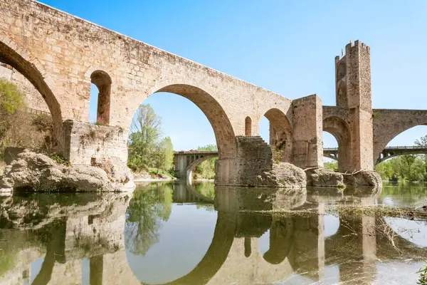 Besalu 'nun ortaçağ köprüsü her iki tarafında taş bir duvarla Fluvia Nehri' ni geçer. Köprü eski ve kırsal bir görünümü var..