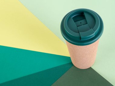 Arka planda yeniden kullanılabilir fincanlar, yeşilin farklı tonlarında. Çevre ve sürdürülebilirlik. 