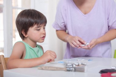 Bir erkek el işi yapmaya hazırlanırken bir kadın bunu yapmak için gerekli malzemeyi hazırlar.. 