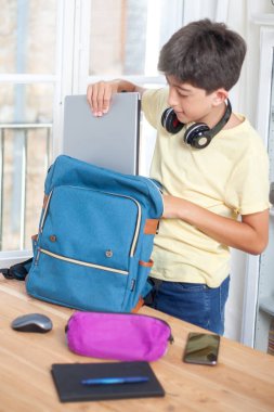Genç kız dizüstü bilgisayarını okul çantasının içinde okula dönmeye hazırlanıyor.. 