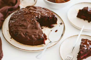 Beyaz ahşap masada kirazlı çikolatalı kek.
