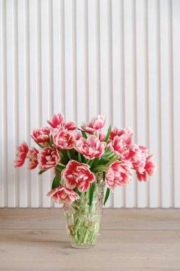 Ahşap arka planda vazoya pembe lale buketi. Yıldönümü kutlaması. Uzayı kopyala Ön görünüm