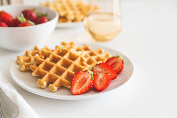 Belgian waffles with strawberry on white plate. Breakfast food concept. Copy space