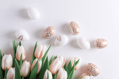 Pembe lale buketinden, paskalya yumurtalarından ve beyaz arka plandaki oyuncaklardan. Paskalya kutlaması. Uzayı kopyala Üst görünüm