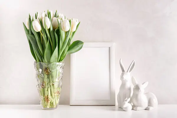 Leere Holzeinfassung Mit Osterhasenfiguren Und Strauß Weißer Tulpen Auf Weißem Stockfoto