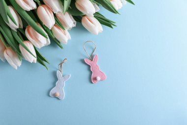 Mavi arka planda pembe lale buketi ve Paskalya oyuncakları. Paskalya kutlaması. Uzayı kopyala Üst görünüm