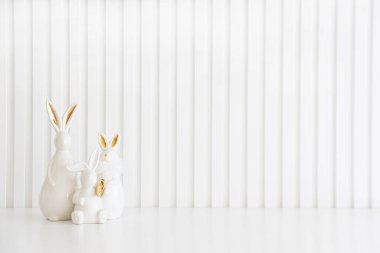 Beyaz arka planda Paskalya tavşanları heykelcikleri ve yumurtalar. Paskalya kutlaması. Uzayı kopyala Ön görünüm