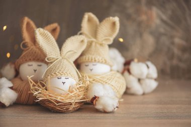 Örgü örülmüş şapkaların içinde paskalya yumurtaları ve yuvada tavşan kulakları. Paskalya kutlaması kavramı