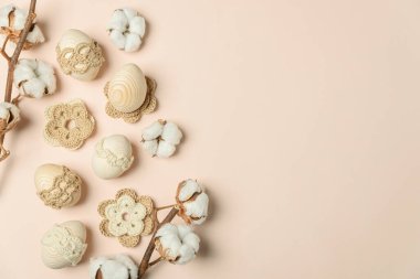 Yumuşak bej arka planda el yapımı yumurta, örgü ve pamuk çiçekleri. Üst Manzara. Boşluğu kopyala