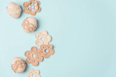 El yapımı yumurta ve mavi arka planda örülmüş çiçekler. Üst Manzara. Boşluğu kopyala