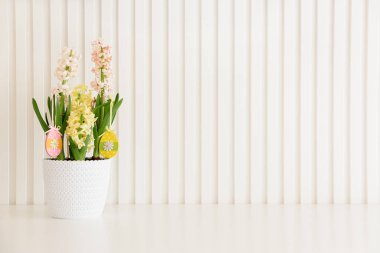 Sümbüller beyaz arka planda Paskalya ahşap yumurta oyuncakları süslemişler. Paskalya kutlaması. Uzayı kopyala Ön görünüm