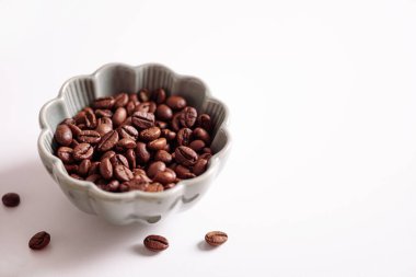 Kahve çekirdekleri beyaz masada kaseye konur. Üst Manzara. Yumuşak odak
