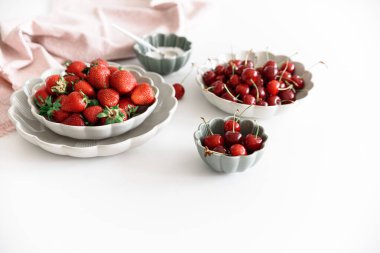 Taze yaz meyvelerini beyaz masada kaselere koyarız. Yaz yemekleri konsepti. Yumuşak odak