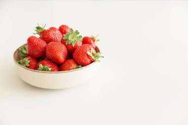 Beyaz masadaki kaselere taze çilek. Yaz yemekleri konsepti. Yumuşak odak