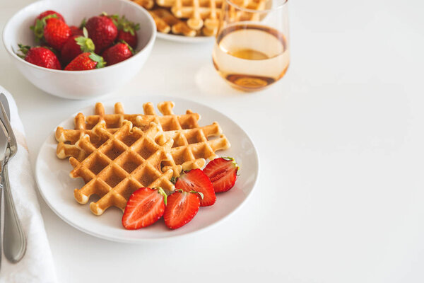 Belgian waffles with strawberry on white plate. Breakfast food concept. Copy space. Top view