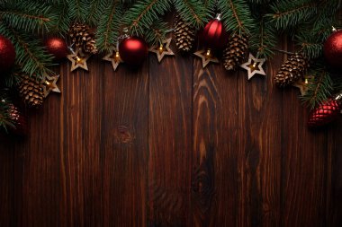 Noel arka planında köknar dalları, koniler, kırmızı mücevherler ve tahta üzerinde yıldız şeklinde ışıklar var. Üst Manzara. Uzayı kopyala Xmas dekorasyonu