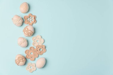 El yapımı yumurta ve mavi arka planda örülmüş çiçekler. Üst Manzara. Boşluğu kopyala